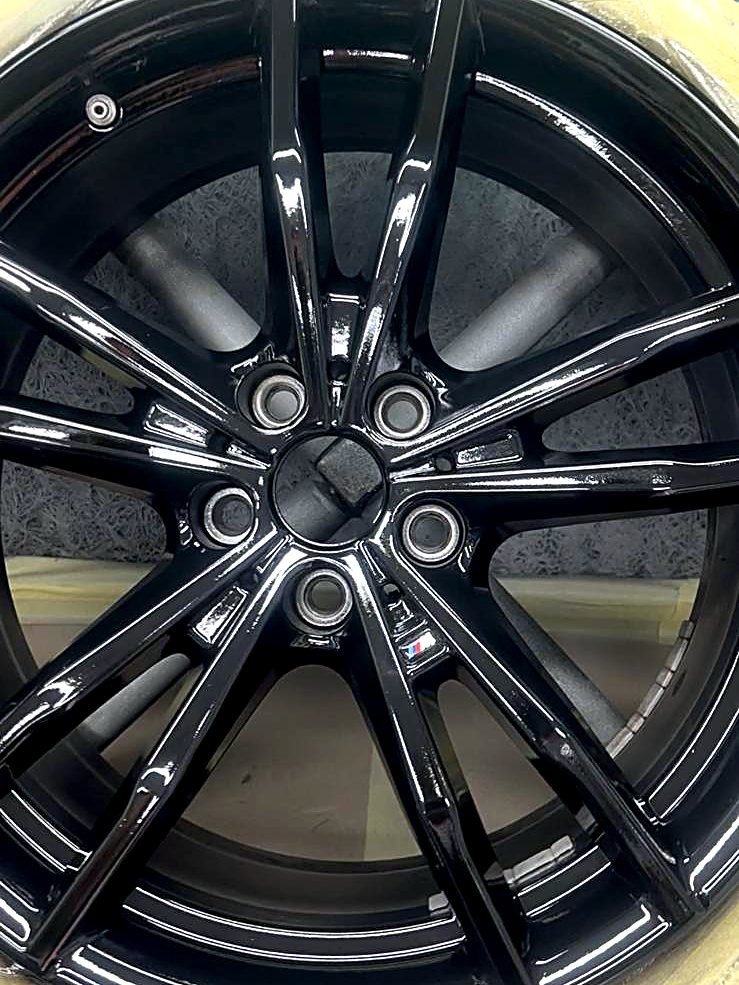 Freshly painted gloss black BMW double-spoke alloy wheel